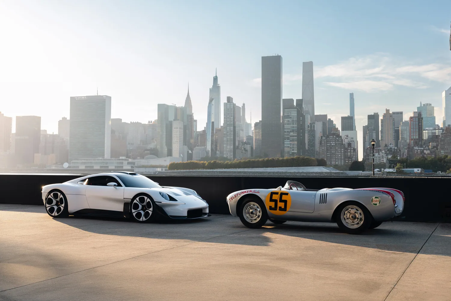 Porsche Mission S จอดคู่กับ Porsche 550 Spyder โดยมีเส้นขอบฟ้าแมนแฮตตันเป็นฉากหลัง