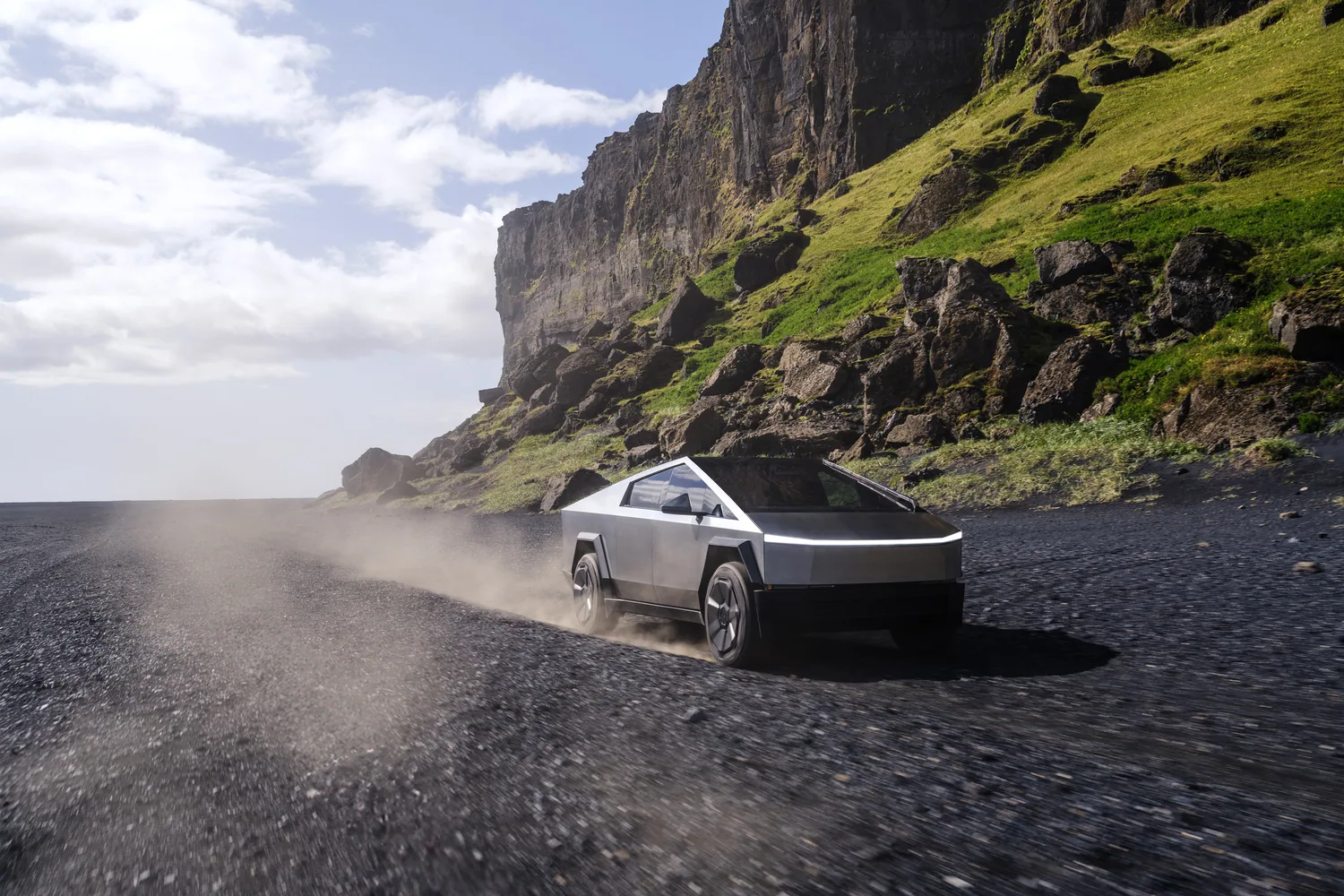 รถกระบะไฟฟ้า Tesla Cybertruck ขับบนทางฝุ่นริมหน้าผา