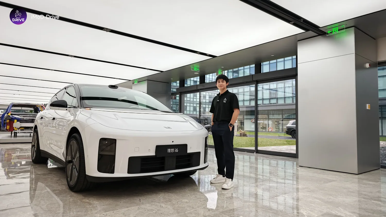 Li Auto i6 สีขาวในโชว์รูมพร้อมผู้ดำเนินรายการ